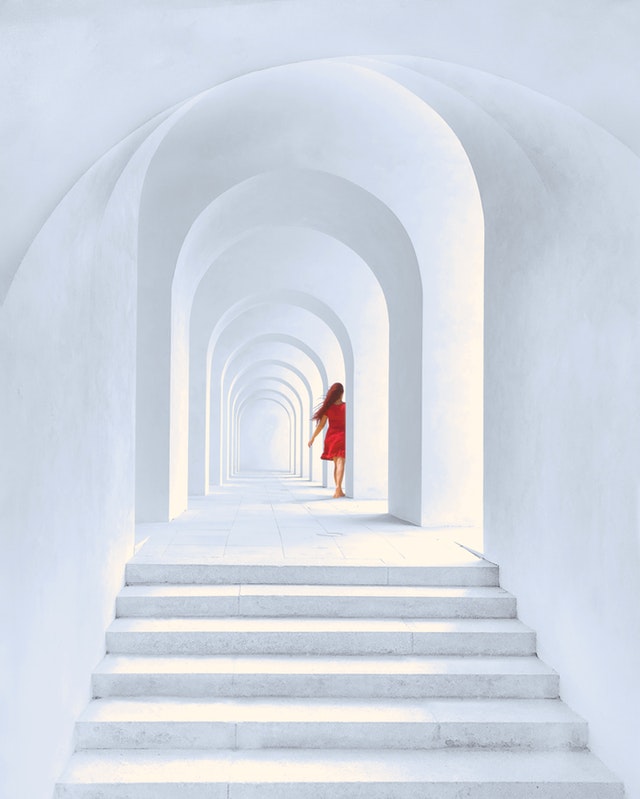 A lady in red in a labyrinth of hallways